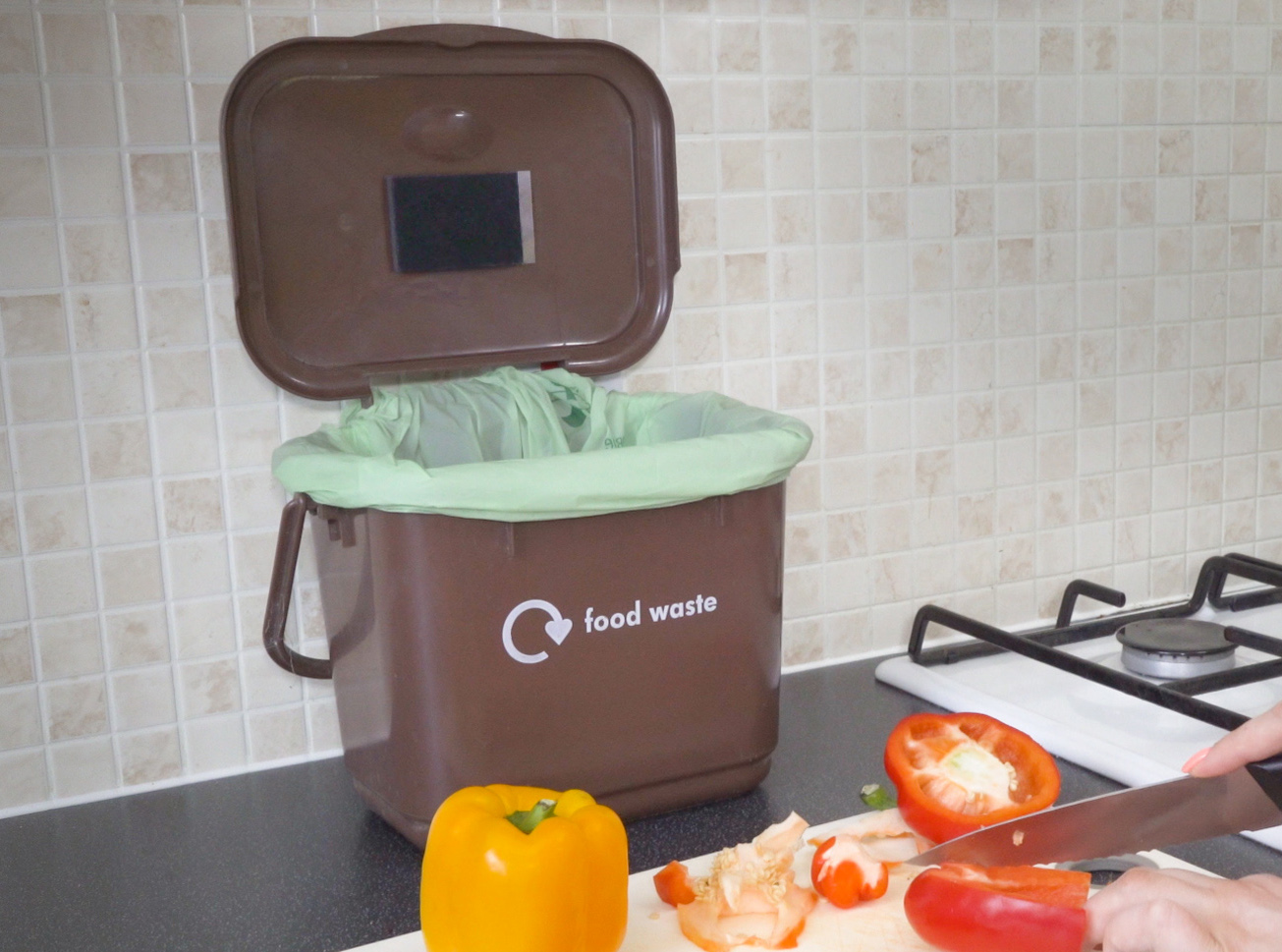 Lifestyle picture of the patch stuck to the lid of a food waste bin.