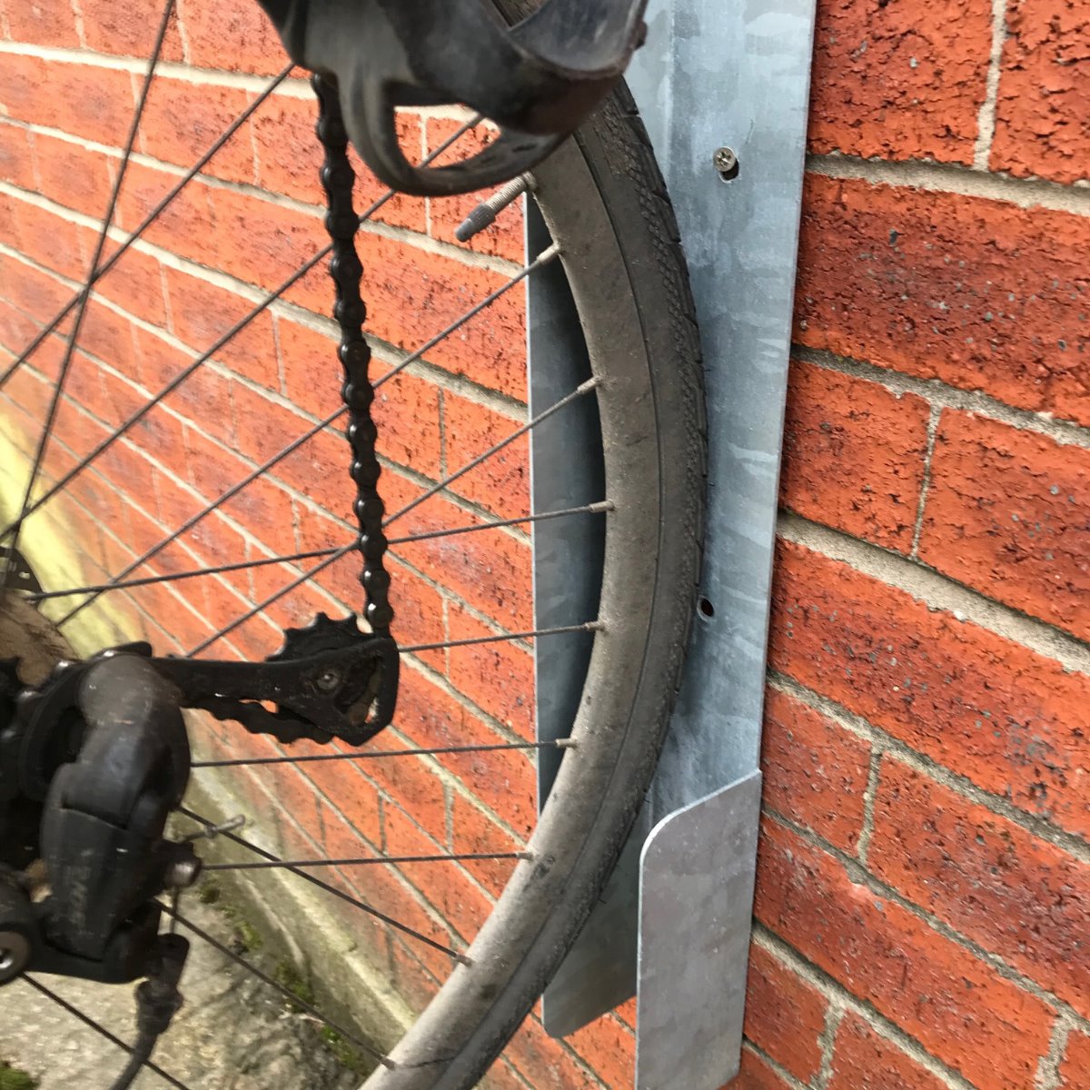Close up of the Eltham vertical cycle trough connected to a wall and bike.